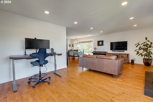 living room featuring light hardwood / wood-style flooring and an inviting chandelier