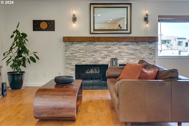 living room featuring a stone fireplace and hardwood / wood-style floors