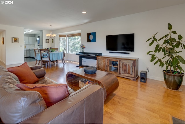 living room featuring light wood-type flooring and a chandelier