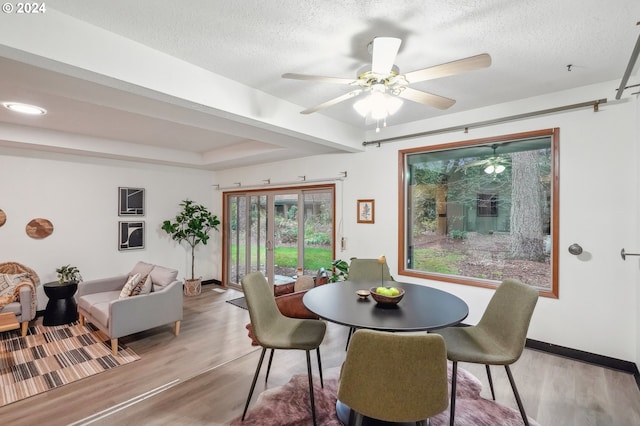 dining space featuring hardwood / wood-style flooring, ceiling fan, and a textured ceiling