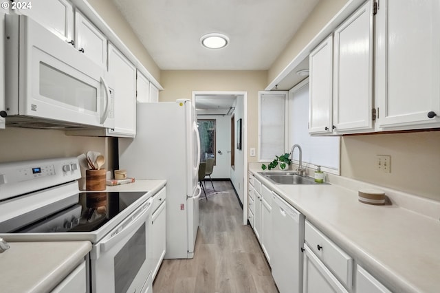 kitchen featuring white cabinetry, sink, white appliances, and light hardwood / wood-style flooring