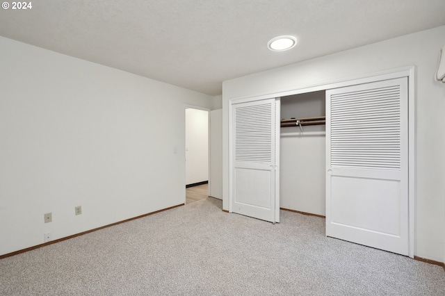 unfurnished bedroom with light carpet and a closet