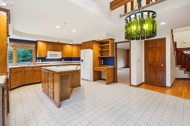 kitchen featuring a kitchen island, light wood-type flooring, white appliances, and a chandelier