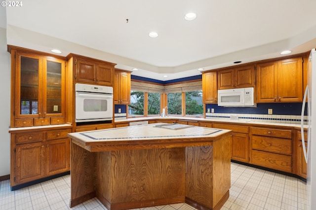 kitchen featuring white appliances, a kitchen island, and backsplash