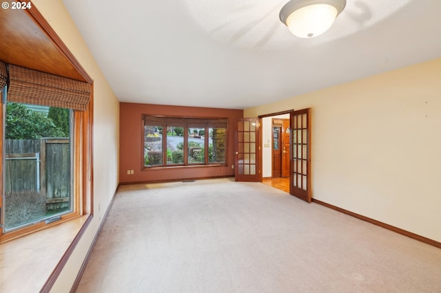 empty room with french doors and light colored carpet