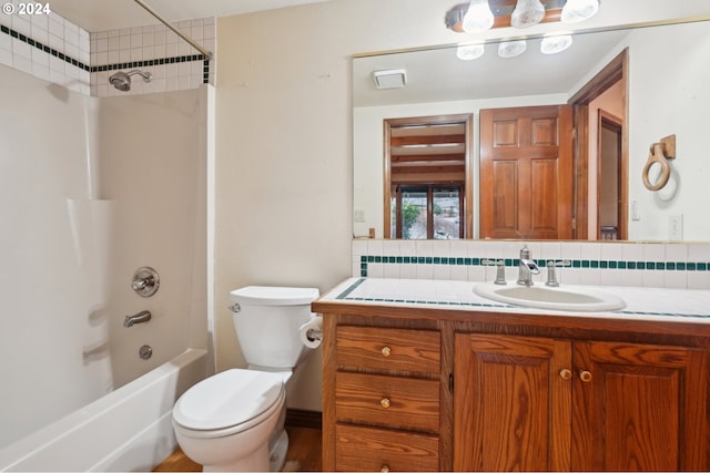 full bathroom with tasteful backsplash, toilet, vanity, and tiled shower / bath