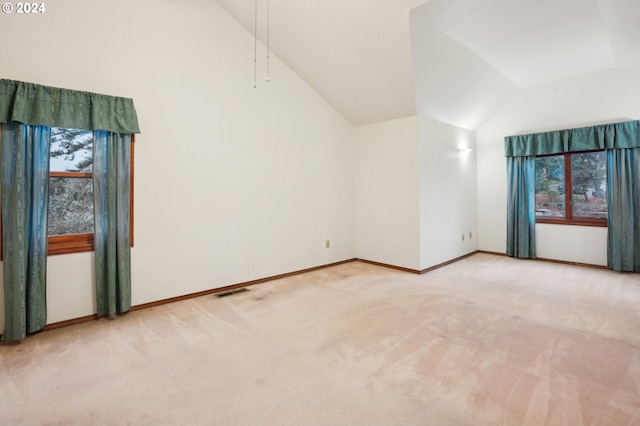 carpeted empty room featuring a healthy amount of sunlight and vaulted ceiling