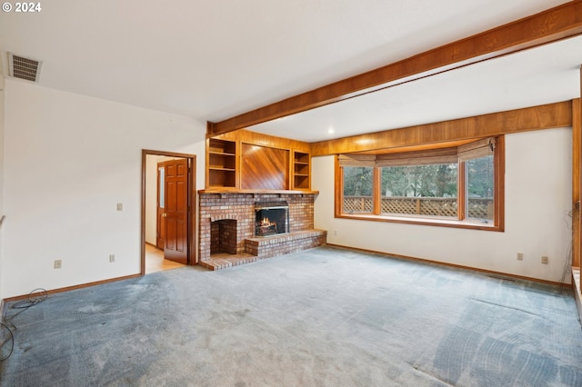 unfurnished living room featuring built in shelves, light colored carpet, and a brick fireplace