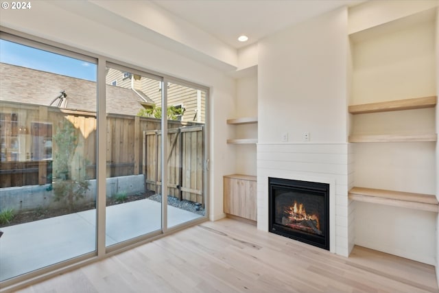 entryway featuring light hardwood / wood-style floors, a fireplace, and built in shelves