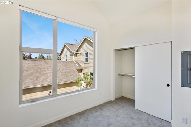 unfurnished bedroom with vaulted ceiling, a closet, and carpet floors