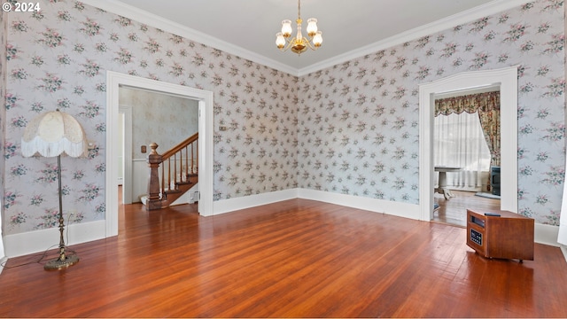 spare room featuring baseboards, stairway, an inviting chandelier, and wood finished floors