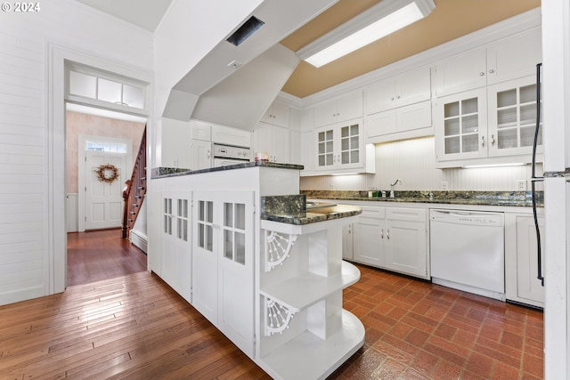 kitchen with dark stone countertops, white cabinetry, sink, and white appliances