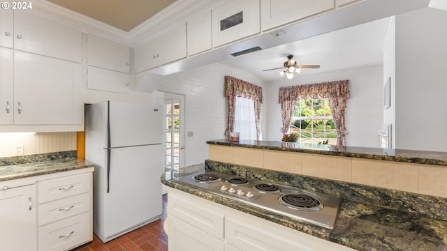 kitchen featuring white cabinetry, stainless steel electric cooktop, dark stone counters, and white refrigerator