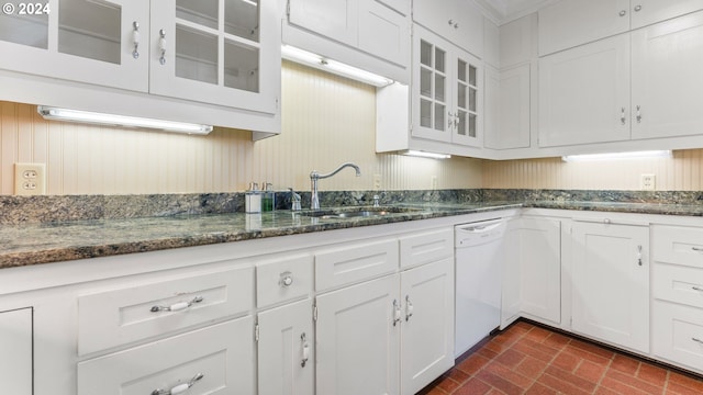 kitchen featuring dishwasher, white cabinetry, dark stone counters, and sink