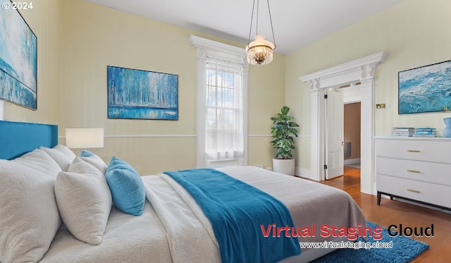 bedroom with hardwood / wood-style floors and a chandelier