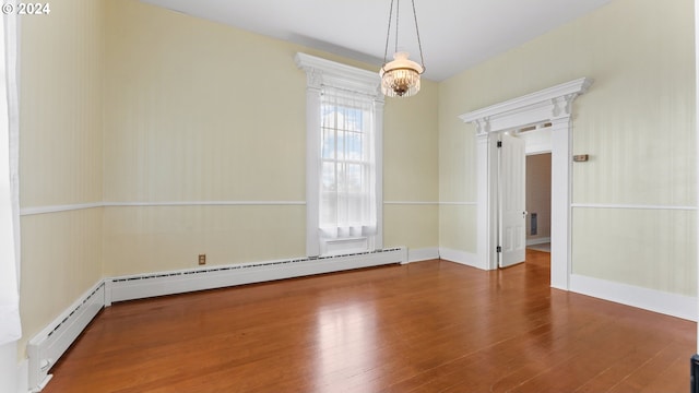 unfurnished dining area with a baseboard radiator, an inviting chandelier, and wood finished floors