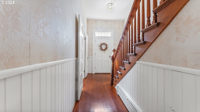 corridor with dark hardwood / wood-style flooring and a baseboard heating unit