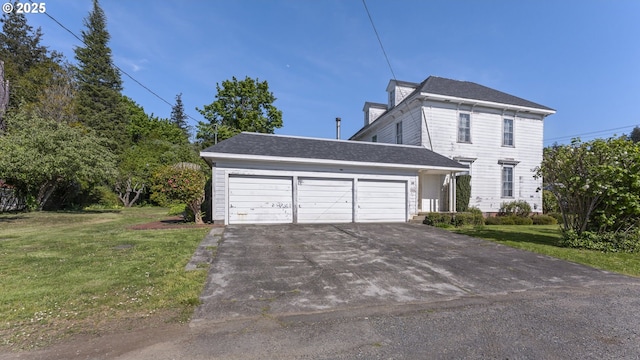 view of front of home featuring a front yard, aphalt driveway, and a garage