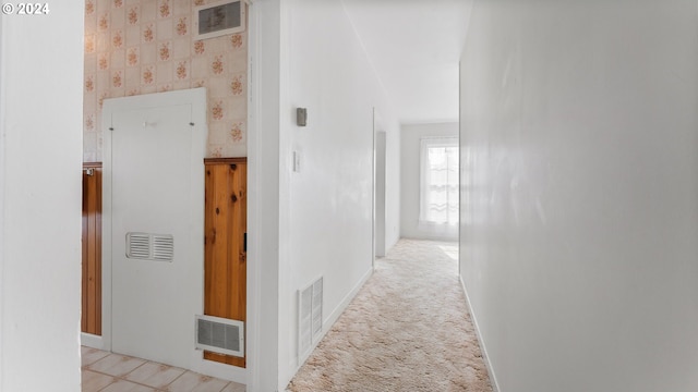 hall with light colored carpet