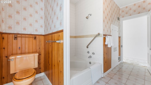 bathroom featuring tiled shower / bath combo and toilet