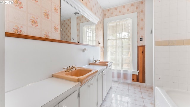 bathroom featuring vanity, a tub, visible vents, baseboards, and wallpapered walls