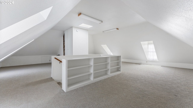 bonus room featuring a textured ceiling, carpet flooring, and vaulted ceiling with skylight