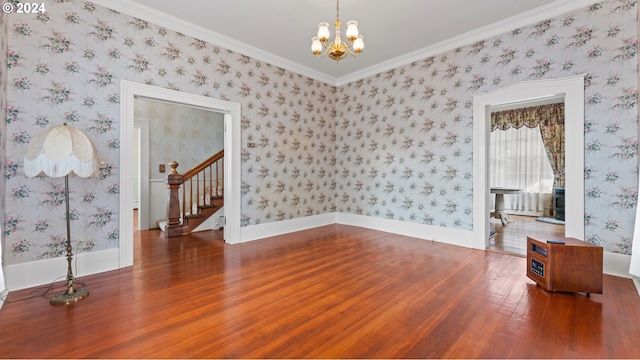 unfurnished room with hardwood / wood-style floors, a notable chandelier, and ornamental molding