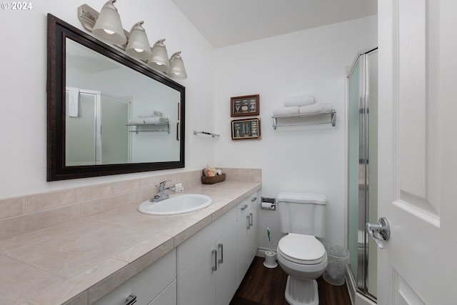 bathroom featuring hardwood / wood-style floors, vanity, toilet, and a shower with shower door