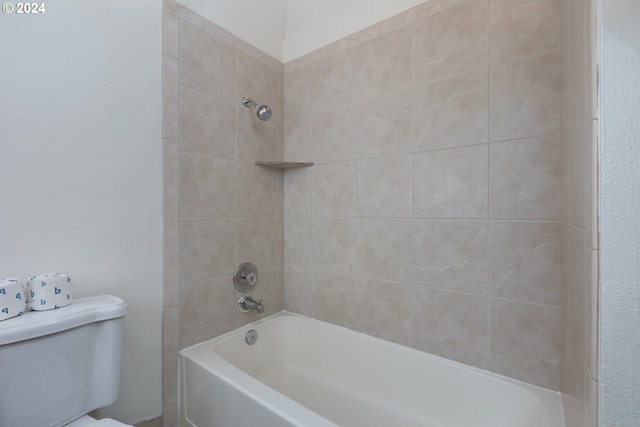 bathroom with toilet and tiled shower / bath