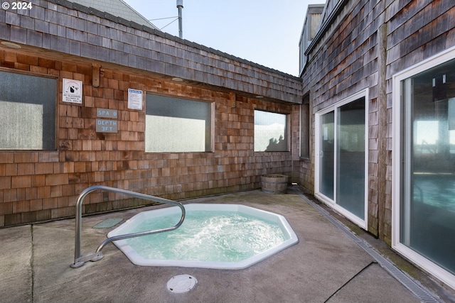 view of swimming pool with a hot tub