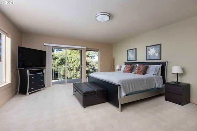 carpeted bedroom with a textured ceiling and access to outside