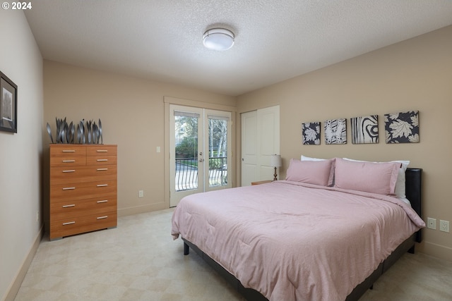 bedroom featuring access to exterior, a textured ceiling, light carpet, and french doors