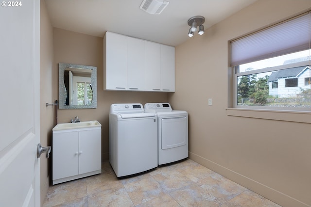 washroom with cabinets, sink, and washer and dryer