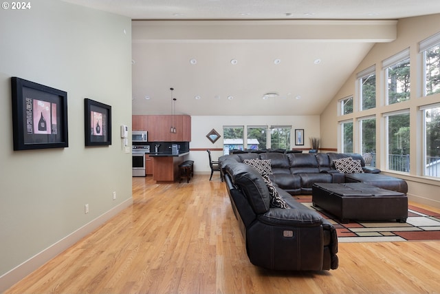 living room featuring high vaulted ceiling, beam ceiling, a wealth of natural light, and light hardwood / wood-style flooring