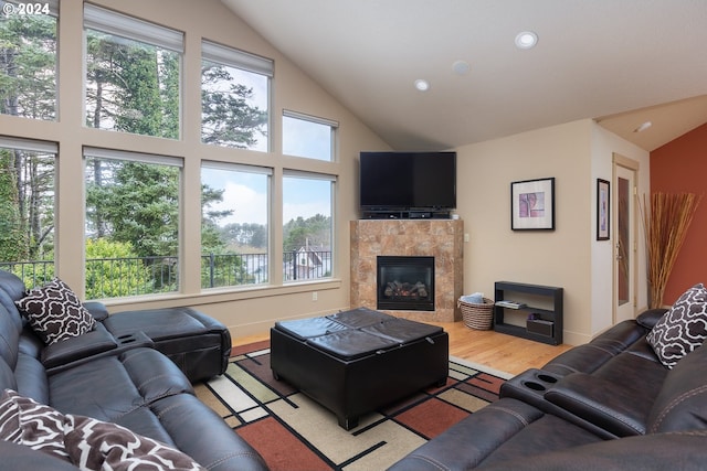 living room featuring plenty of natural light, a tile fireplace, and light wood-type flooring