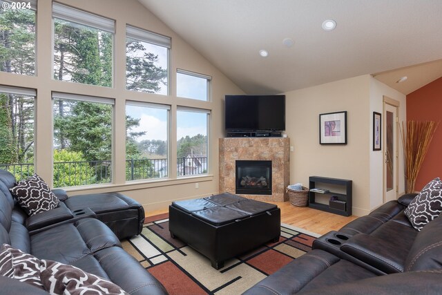 2777 NW Neptune Ave, Lincoln City, OR 97367 - living area with wood finished floors, high vaulted ceiling, a tile fireplace, recessed lighting, and baseboards