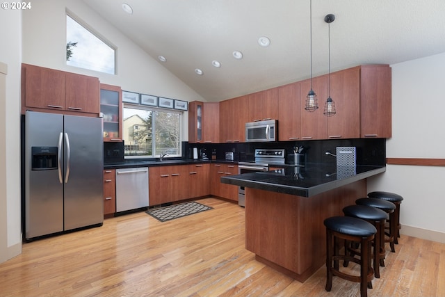 2777 NW Neptune Ave, Lincoln City, OR 97367 - kitchen with stainless steel appliances, a peninsula, dark countertops, tasteful backsplash, and high vaulted ceiling