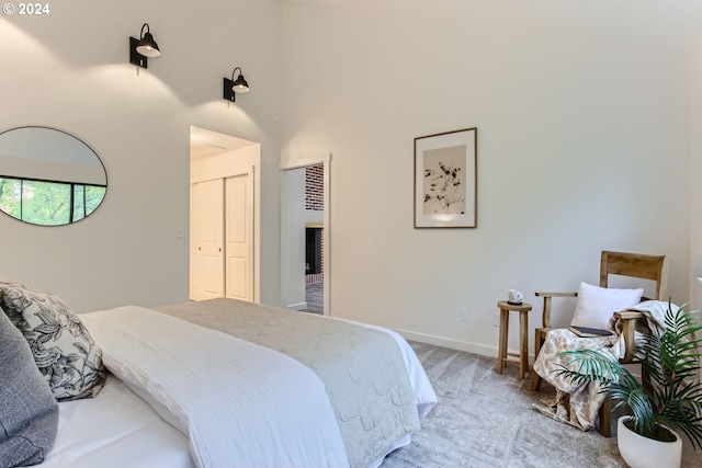 bedroom featuring carpet, a high ceiling, and a closet