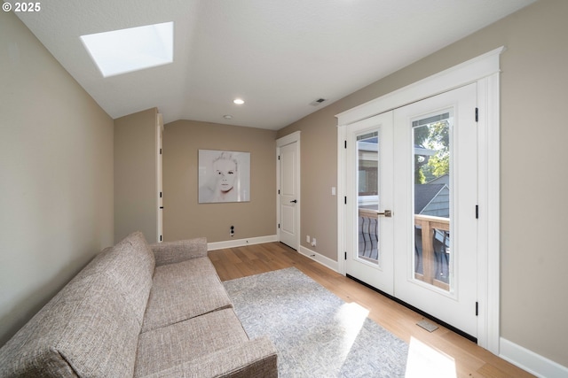 entryway with french doors, light hardwood / wood-style flooring, and lofted ceiling with skylight