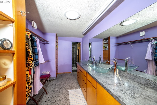 interior space with a textured ceiling and sink