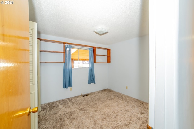 carpeted spare room with a textured ceiling