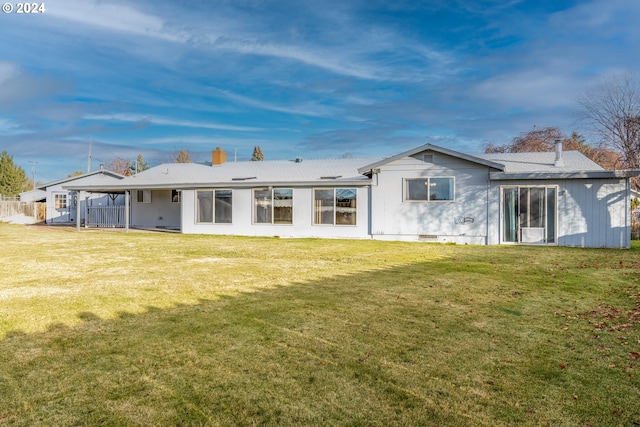 rear view of property featuring a lawn