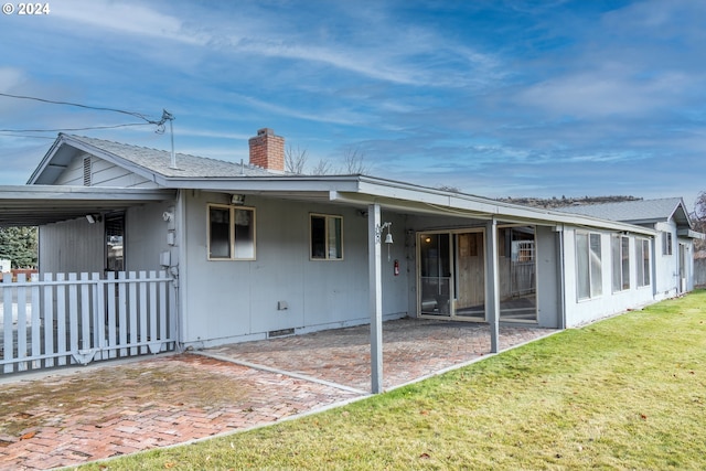 rear view of property with a lawn and a patio