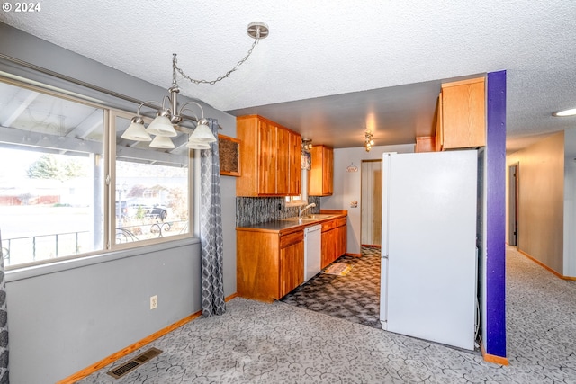 kitchen with white appliances, backsplash, sink, a textured ceiling, and a notable chandelier