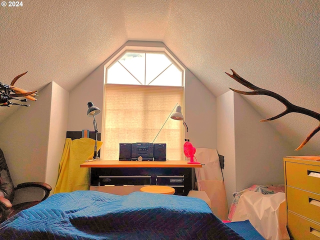 bedroom featuring vaulted ceiling and a textured ceiling