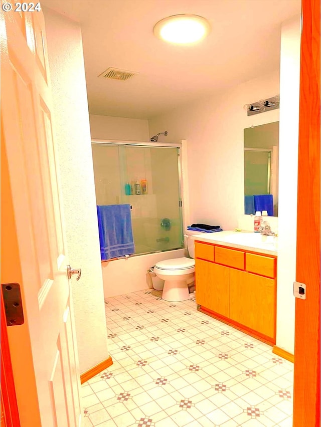 full bathroom featuring visible vents, vanity, toilet, and enclosed tub / shower combo