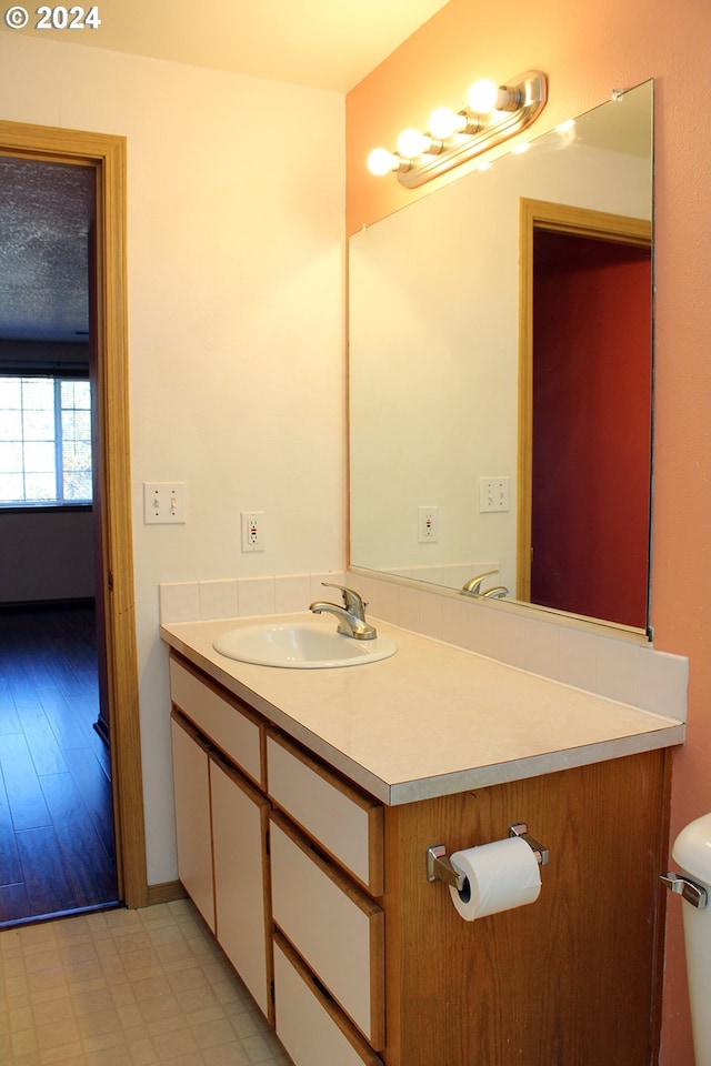 bathroom featuring toilet, vanity, and hardwood / wood-style flooring