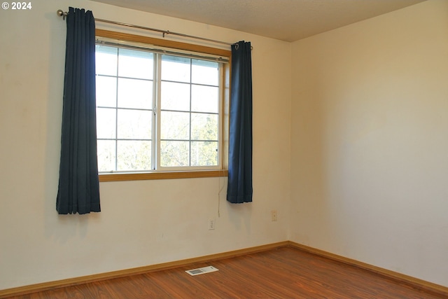 empty room featuring hardwood / wood-style floors and a textured ceiling