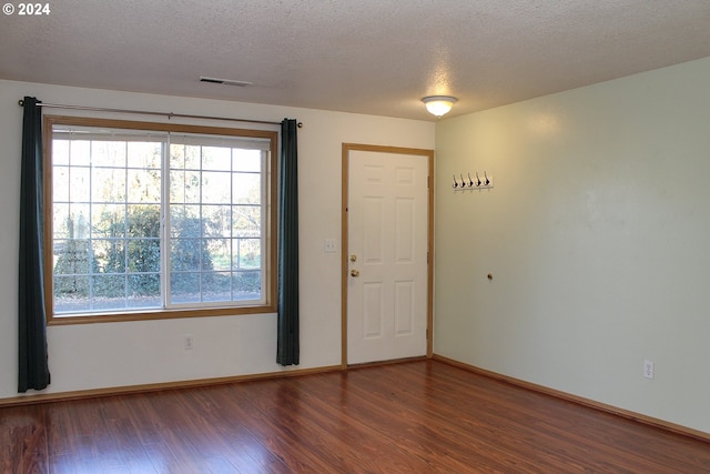 foyer with dark hardwood / wood-style flooring and a textured ceiling