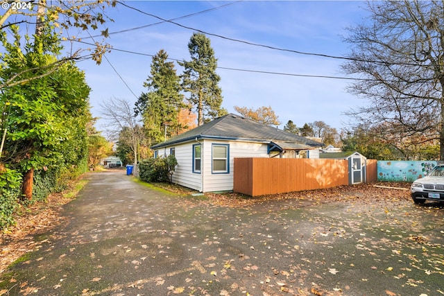 view of side of property featuring a storage shed